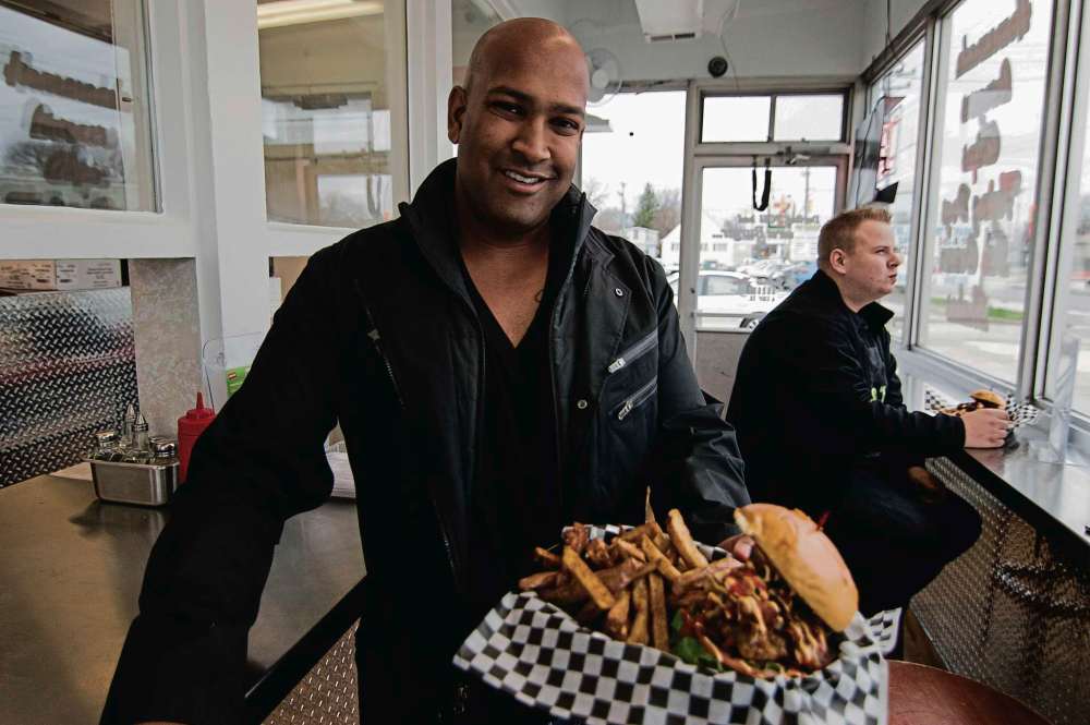 Alana Trachenko
St. James Burger & Chips Co. owner Ravi Ramberran shows off the restaurant’s After-Burner burger and chips. The shop is now open at 1866 Ness Ave.