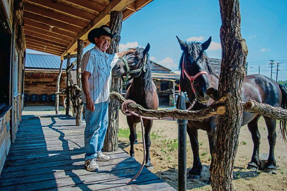 Alana Trachenko
John Trowbridge with his horses Burt and Duchess at Unique Corral. Trowbridge built the old western-style town and rents it out for parties.