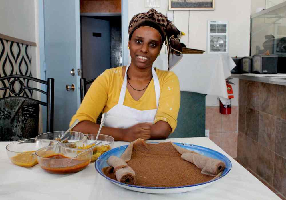 Cindy Chan
Tedane Molla, one of the owners of Queen Sheba Restaurant and Bar, is pictured with one of the restaurant’s most popular dishes, the Ethiopian vegetarian platter.