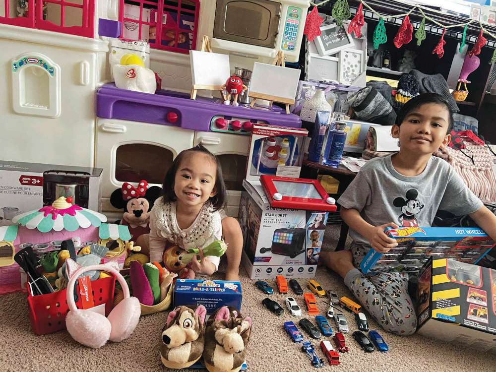 Supplied photo
Nine-year-old Cary Perez (at right) and his three-year-old sister Oleevya, are pictured with some of the items their family received in their Charleswood Cheers hamper, which even included a Little Tykes kitchen.