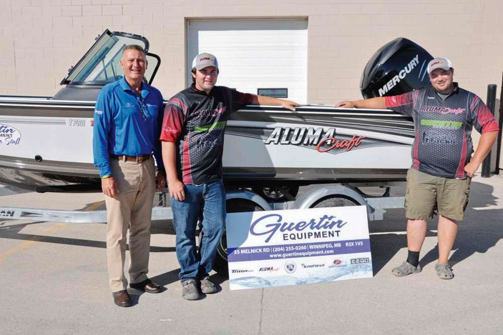 Supplied photo
From left to right: Michael Guertin poses with Eric and Garret Barker and the boat Guertin Equipment is donating to the brothers’ Cast 4 Kids efforts this year.