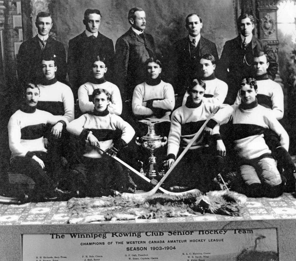 Manitoba Sports Hall of Fame & Museum
Team photo of the Winnipeg Rowing Club senior hockey team, 1903-04. There are nine players and five associates. Only 11 names are visible, they are: H.H. Richards, secretary-treasurer; F.H. Bole, Comm.; G.F. Galt, president; R.A.C. Manning, Comm.; P.E. Browne, Point; J. Hall, Rover; W. Breen, Captain-Centre; W.R. Bawlf, Wing; H. Sullivan, Trainer; C. Bowland, Wing and H. Kirby, Spare.
