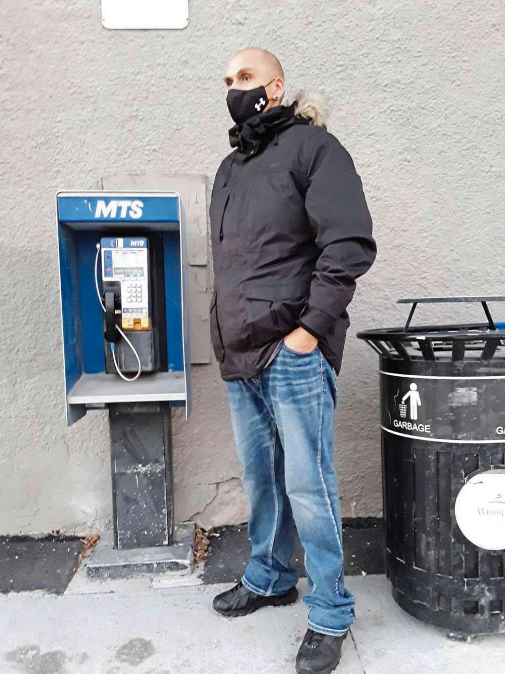 Photo by Shirley Kowalchuk
Longtime neighbourhood resident Joshua Wheelright (who carries a cell phone) strolls by the payphone at Jamison Food Mart.