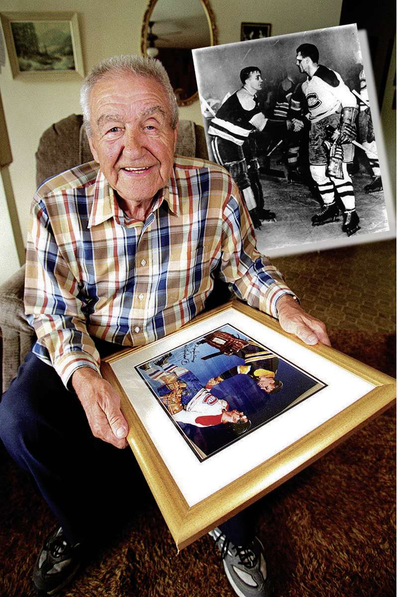 Photo by Phil Hossack / Winnipeg Free Press files
Former Boston Bruin's goaltender, Sugar Jim Henry reminices about the night the Rocket Richard came back into the Stanly Cup Final game to score a last minute goal agains him in the early fifties. He holds a painting (reproduced from a newsphoto) showing the Rocket shaking his hand after the game. Turner's tale.