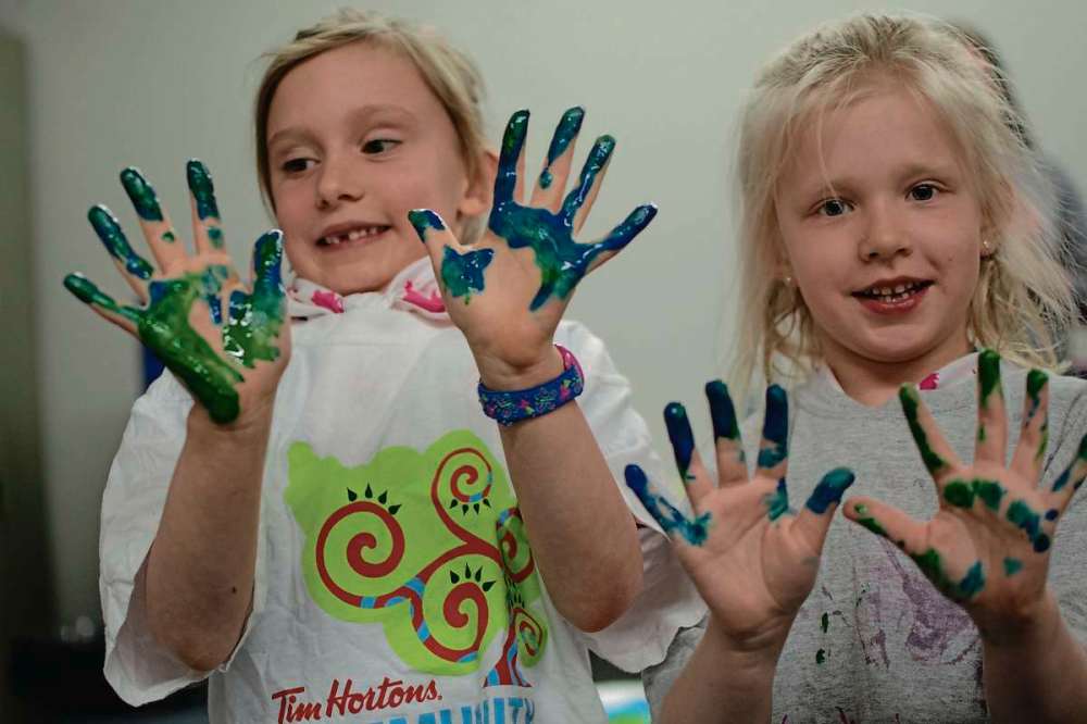 Eva Wasney
Dana Larson and Lily Rogowsky, participants in the Girl Guides Sparks group that meets at Deer Lodge Community Centre once a week, show off the results of a finger painting activity.