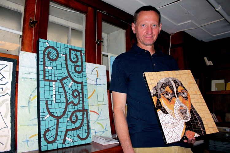Jordan Thompson/Canstar Community News
Dimitry Melman poses with one of his mosaic pieces in his studio in the basement of his home.