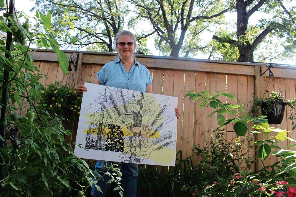 Photo by Kelsey James
Printmaker Karen Cornelius holds up one of the works that will be featured in her new exhibit, Growing Going Gone.