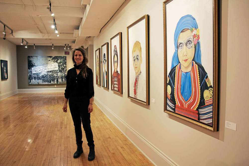 Photo by Katlyn Streilein
Kerri Parnell is seen here with a series of five paintings representing the cultural groups primarily impacted by the internment camps.