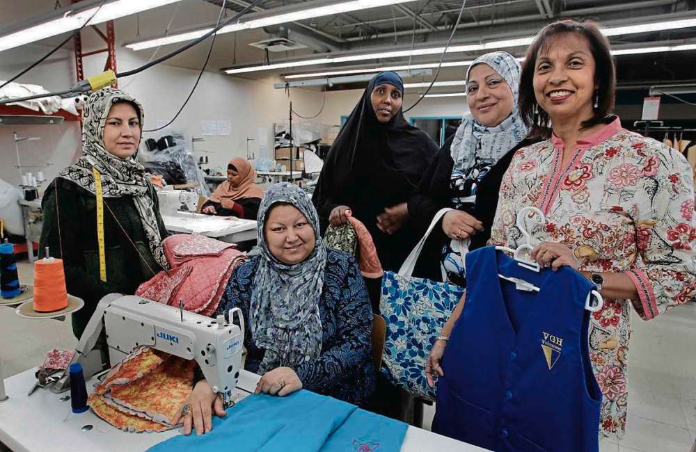 Supplied photo
Yasmin Ali (far right) and SewFair women making vests for the Victoria General Hospital.