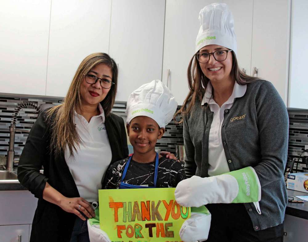 Photo by Sydney Hildebrandt
Janina Gomez and Alyssa Dueck of easyfinancial stand with Roba Muhmed (centre) at the Gilbert Park Boys and Girls Club to celebrate the newly renovated kitchen.