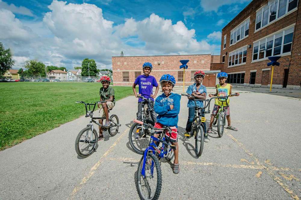 Supplied photo by the Winnipeg Foundation
Kids show off refurbished bikes given to them by the WRENCH.