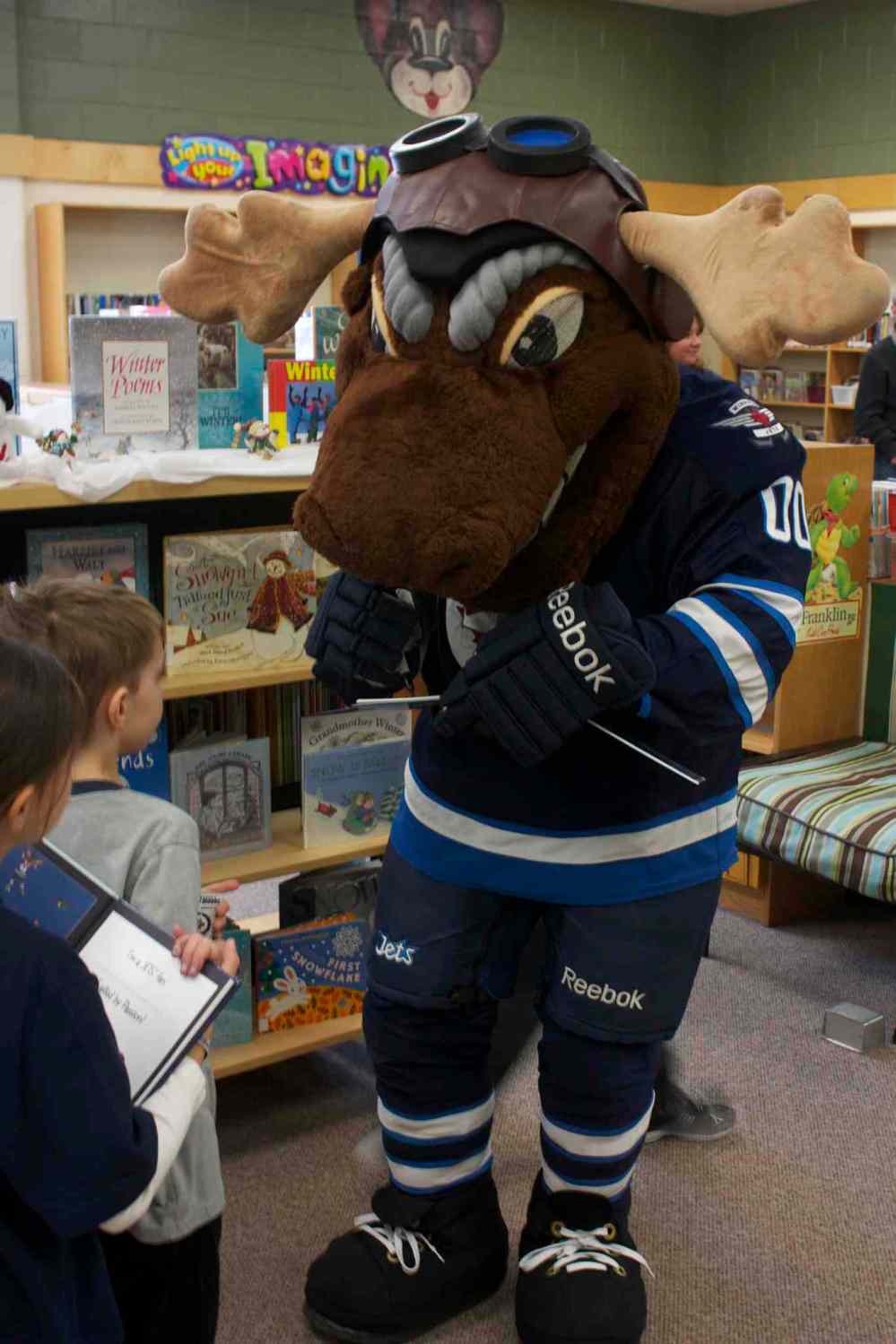 Photo by Dan Falloon
Winnipeg Jets mascot Mick E. Moose signs a copy of The Home Team for a young fan at Princess Margaret School. Centre Mark Scheifele and defenceman Zach Bogosian also attended the I Love to Read Month event through the team's Reading Takes Flight program.