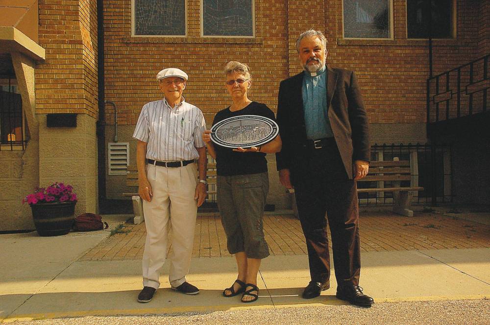 File photo
Dr. Semeon Hrushowetz, Joanne Lewandowski, and Fr. Michael Kwiatkowski of Holy Eucharist Parish are pictured in 2014 with one of 100 plaques marking the 100th anniversary of the beginning of Ukrainian internment in Canada.