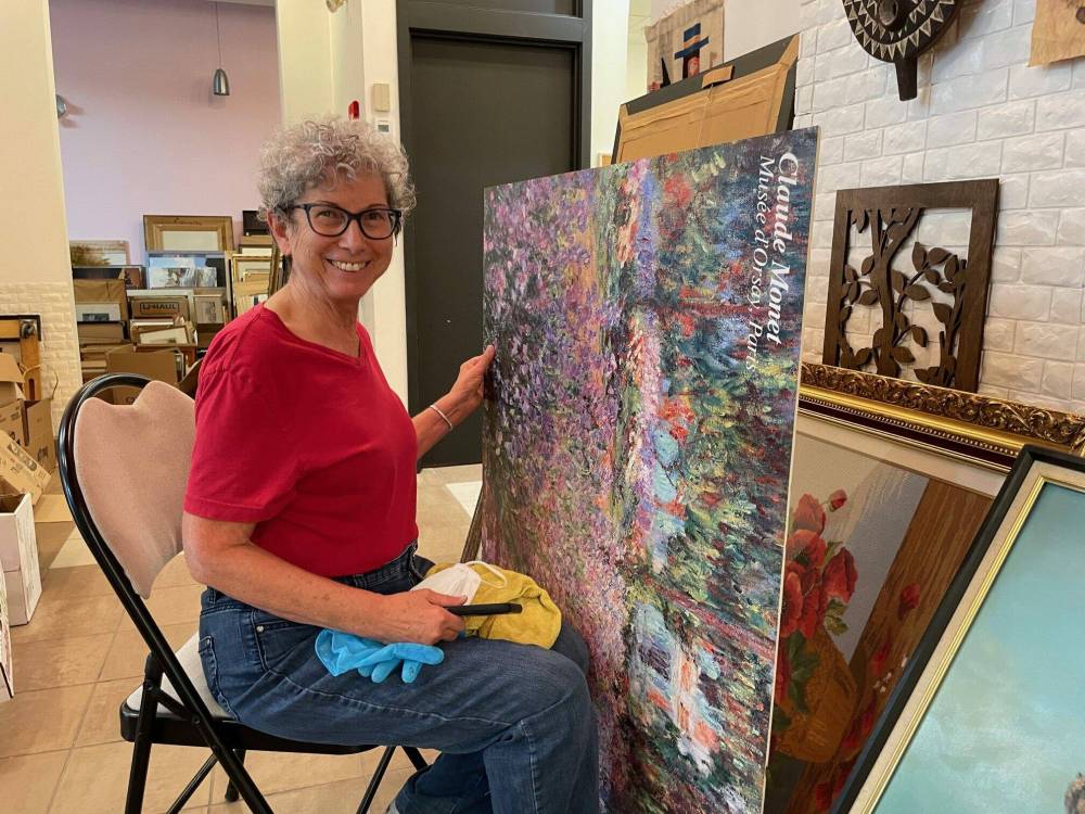 Supllied photo
Art from the Attic volunteer Charleen Frenette is pictured cleaning an art donation. This year’s annual fundraiser will be held on Oct. 6 at St. Vital Centre.