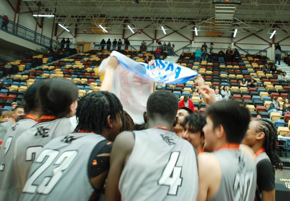 Members of the victorious Reivers celebrate with the championship banner.