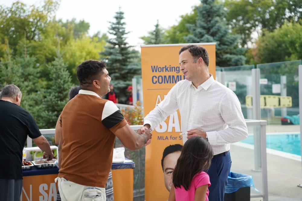 Supplied photo
St. James MLA, Adrien Sala, speaking with a constituent during a community BBQ at Hillsboro House in July 2025.