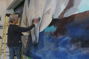 Photo by Rylee Gerrard
                                Kal Barteski painting a polar bear as part of the new mural at the Tundra Grill.
