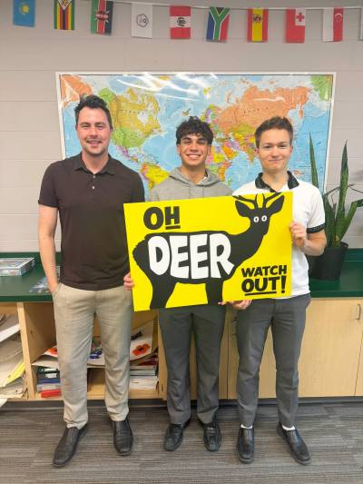Supplied photo
                                Teacher Joshua Enns (from left) and St. John&rsquo;s-Ravenscourt students Zachary Zegalski and Rhys Jassal pose with the &lsquo;Oh Deer&rsquo; signs the boys created for a school project and distributed in Wildwood.