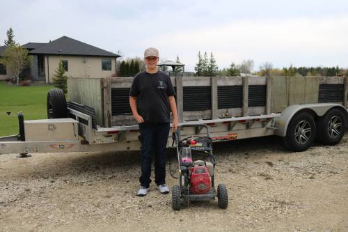Photo by Rylee Gerrard
                                Will Thys with his power washer, foam canon, and the trailer he loads with bins.