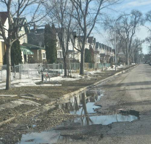 Photo by Doug Kretchmer
                                Pothole season has returned to Winnipeg, a fact community correspondent Doug Kretchmer learned first hand when this massive pothole ripped through two tires on his car recently.