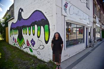 Photo by Doug Kretchmer
                                Anishinaabe artist Jackie Traverse stands before a mural on the wall of the Creative Native Art Gallery (592 Selkirk Ave.), which she owns.