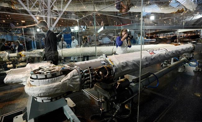 FILE -- People check out the Canadarm permanent display as it is unveiled at the Canada Aviation and Space Museum in Ottawa on Thursday, May 2, 2013. An organization that represents firms in the Canadian space sector says the industry has not been a priority for the current government and it is hoping that will change after the Oct. 19 federal election THE CANADIAN PRESS/Sean Kilpatrick