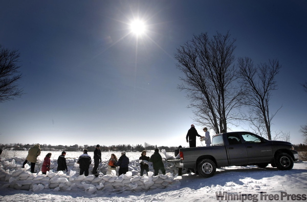 PHIL HOSSACK / WINNIPEG FREE PRESS
A line of sandbaggers works under clear skies Friday outside a home in Lockport, Manitoba.
