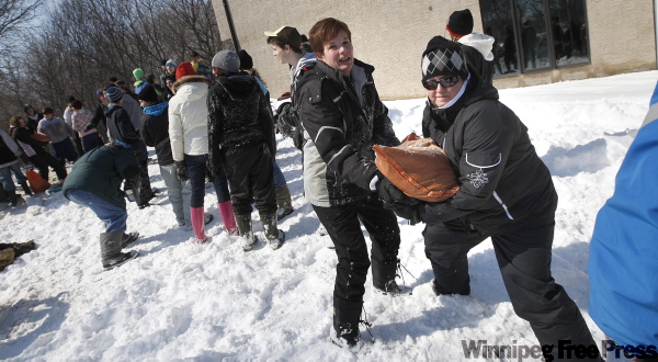 PHIL HOSSACK / WINNIPEG FREE PRESS
Volunteers pass sandbags at Audra and Trent Goodbrandson's home.