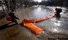 PHIL HOSSACK / WINNIPEG FREE PRESS
City crews move one of the dikes that were overwhelmed in a low section near Christie Road. The dikes were removed to allow emergency access by road.