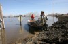 RUTH BONNEVILLE / WINNIPEG FREE PRESS
Ray Shaw (front) and Barry Penner pull their boats ashore onto the Morris ring dike next to Highway 75.