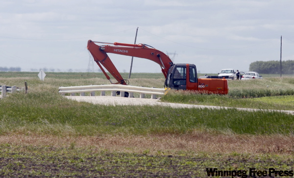 MIKE.APORIUS@FREEPRESS.MB.CA
RCMP officers secure the scene where a backhoe operator found Cherisse Houle’s body Thursday in Sturgeon Creek in the RM of Rosser.