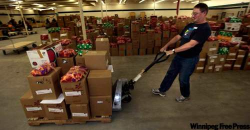 PHIL.HOSSACK@FREEPRESS.MB.CA
Volunteer Bob Worboys moves a pallet of food and Christmas presents at the Christmas Cheer Board warehouse, located this year in the former SIR Sporting Goods store on Ellice Avenue. Last year, the board delivered more than 19,000 hampers to Winnipeg’s less fortunate.