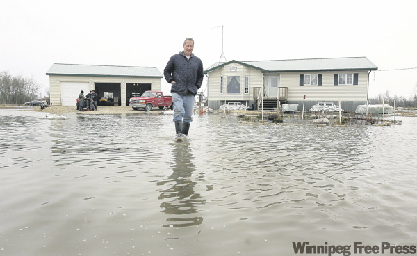 Ruth Bonneville / WInnipeg Free Press
St. Clements resident Roger Trueman walks down what used to be his driveway after being up all night pumping water out of his home.