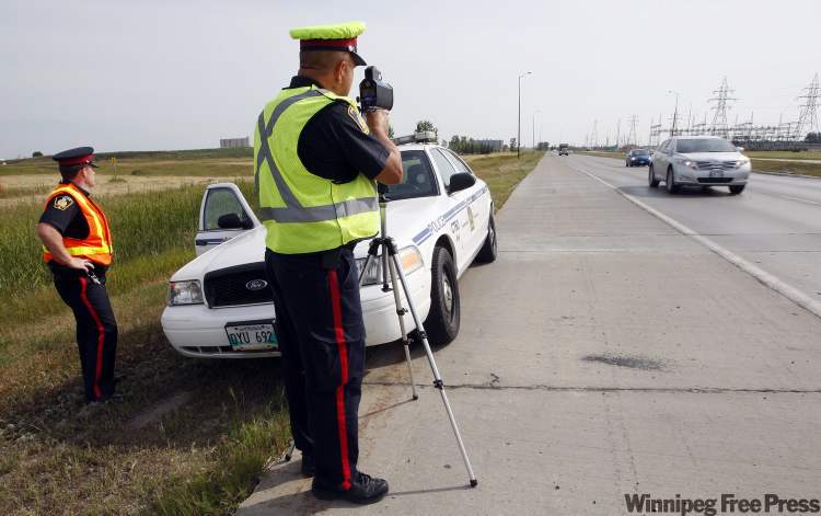 KEN GIGLIOTTI / WINNIPEG FREE PRESS
Winnipeg Police Service Sgt. Mark Hodgson (left) and Sgt. Lou Malo monitor vehicles' speeds on Bishop Grandin Boulevard, where drivers were clocked going at least 50 kilometres per hour over the 80 km/h limit.