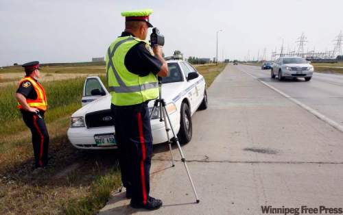 KEN GIGLIOTTI / WINNIPEG FREE PRESS
Winnipeg Police Service Sgt. Mark Hodgson (left) and Sgt. Lou Malo monitor vehicles' speeds on Bishop Grandin Boulevard, where drivers were clocked going at least 50 kilometres per hour over the 80 km/h limit.