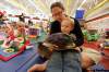 John Woods/Winnipeg Free Press
Bryanna Spina reads to her children Ilia, six months, and Mauro, 3, at Earl Grey Community Club last week. As with many women voters, family issues are important to her.