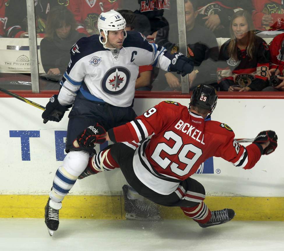 JOE BRYKSA / WINNIPEG FREE PRESS
Winnipeg Jets captain Andrew Ladd, left, send Chicago Blackhawks Bryan Bickell flying in the third period. The Chicago Blackhawks beat the Winnipeg Jets 4-3 Thursday night at the United Centre in Chicago.