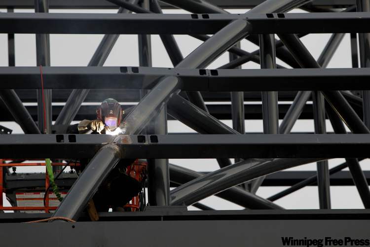 BORIS MINKEVICH / WINNIPEG FREE PRESS
A welder works on a section of the rapid transit corridor near the Osborne Street underpass Thursday.