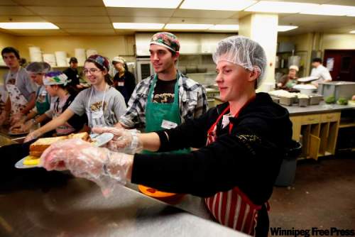 KEN GIGLIOTTI /  WINNIPEG FREE PRESS
Bison track athletes Zac Clapa, Elliott Cooke and Megan Moorehouse (from right) serve breakfast at the Siloam Mission. Over 100 Bison athletes chipped in as servers this year.