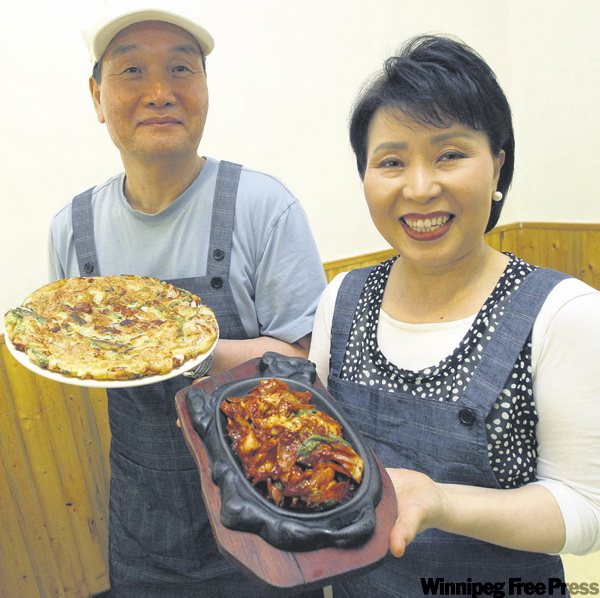 BORIS.MINKEVICH@FREEPRESS.MB.CA
Seok Geon Kim, left, and Myung Ja Baek with Haimool Pajun and chicken bulgogi.