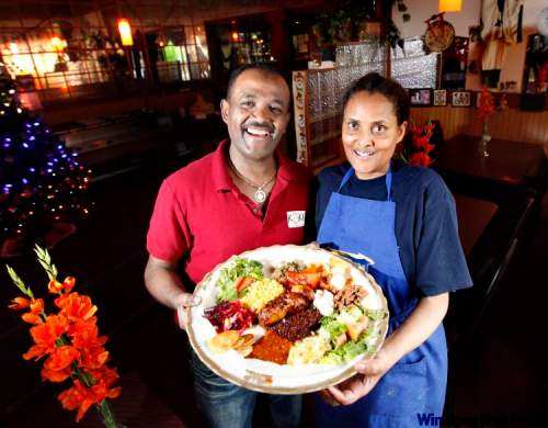 Ruth Bonneville /  Winnipeg Free Press
Robel Arefaine and Hamelamal Shibshi hold a mixed platter from Kokeb Restaurant on Ellice Avenue. Winnipeg restaurant-goers have been enjoying delights from East Africa since the first wave of immigrants arrived on the Prairies in the 1980s.