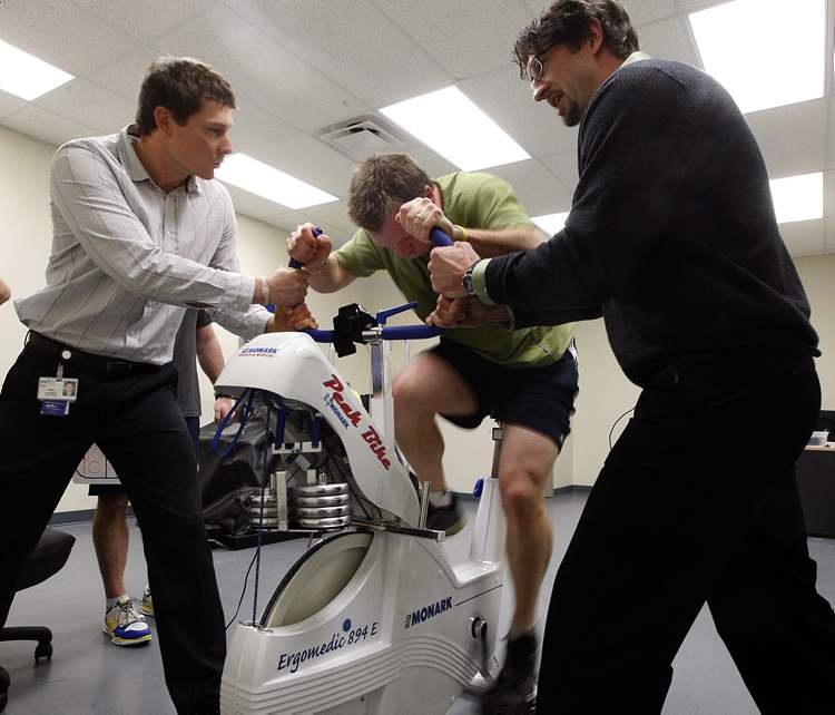 KEN GIGLIOTTI / WINNIPEG FREE PRESS
GEoff Kirbyson takes the tough Wingate test, a maximum effort bike sprint as Brand Gerbrandt, left, and Jeff Leiter give encouragement as they administer the test .