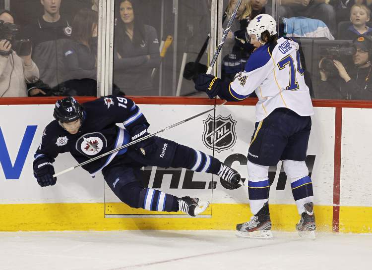 TREVOR HAGAN / WINNIPEG FREE PRESS
The Winnipeg Jets' Jim Slater (19) is knocked over by St. Louis Blues' T.J. Oshie (74) during first period NHL action at the MTS Centre, Saturday.