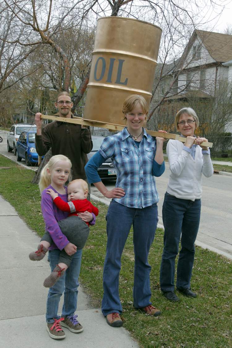 Boris Minkevich / Winnipeg Free Press
FROM LEFT: Mike Smith, Mona Neufeld and Esther Epp-Tiessen hold oil drum they will parade down Portage Avenue. Laurel Smith holds Elias Neufeld.