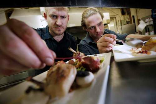John Woods / Winnipeg Free Press archives
Scott Bagshaw, chef and owner of Deseo (left), and his sous-chef Mike Robins put the finishing touches on some young chicken and seared scallops.