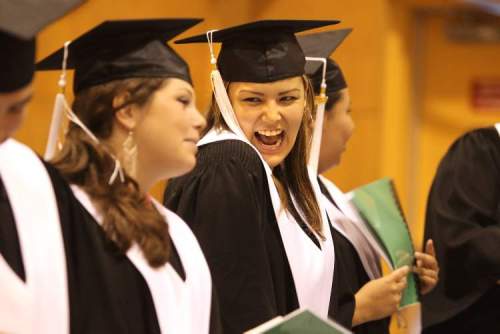 Ruth Bonneville / Winnipeg Free Press 
Rayanna Chartrand (left) smiles and giggles with Kayla Prince (right) during a ceremony in June honouring graduates of the adult-education program at the Turtle Mountain Rec Centre.
