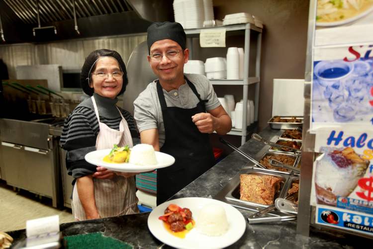 RUTH BONNEVILLE / WINNIPEG FREE PRESS
Lourdes Velasco (part owner) and head chef Dye Castro dish out food.