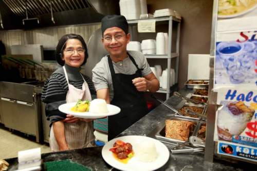 RUTH BONNEVILLE / WINNIPEG FREE PRESS
Lourdes Velasco (part owner) and head chef  Dye Castro dish out food.