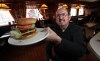 Phil Hossack / Winnipeg Free Press
John Ginakes shows off one of his signature burgers at the Thunderbird Restaurant.