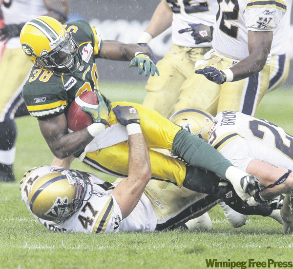 BRIAN J. GAVRILOFF / CANWEST NEWS SERVICE
The Blue Bombers' Pierre-Luc Labbé takes down the Edmonton Eskimos’ Tristan Jackson at Edmonton’s Commonwealth Stadium Thursday night.